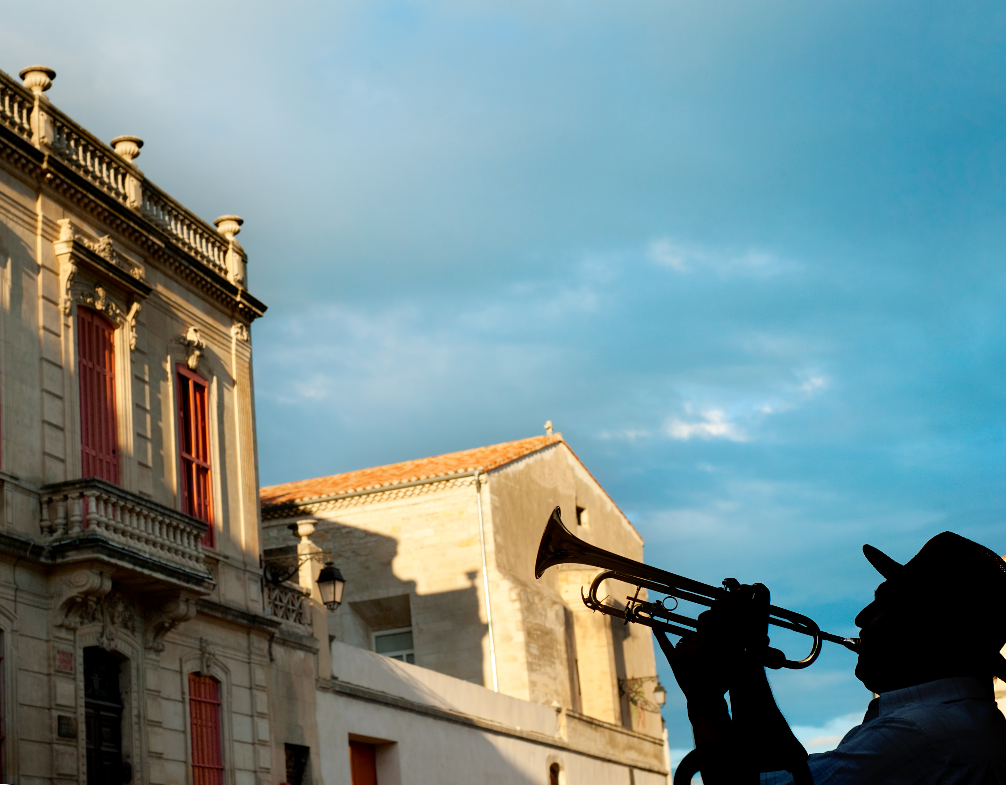 Silhouette of a trumpeter on Arles street, France